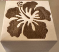 A square wooden box with a dark brown laser-burned hibiscus flower design on the lid.  Perfect for storing small pieces of jewelry or other small items.