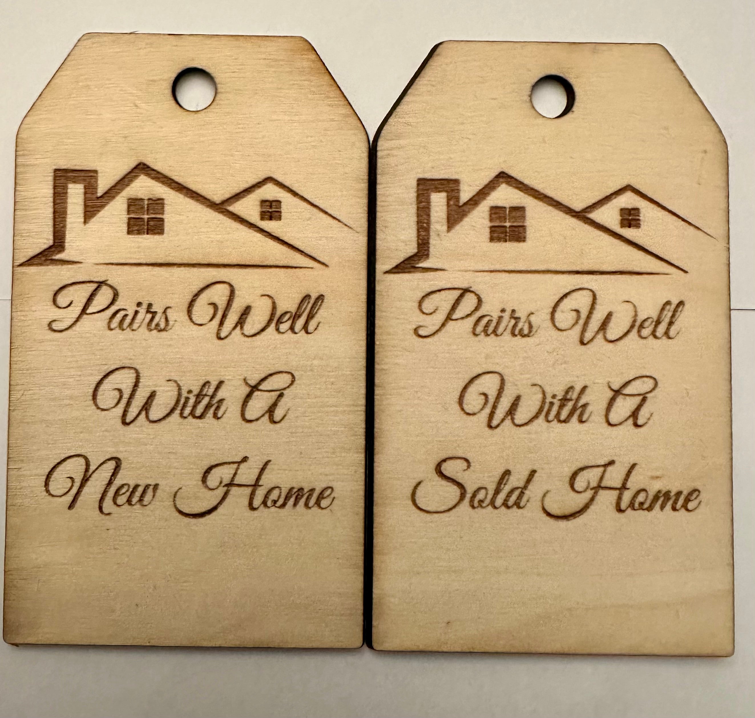 Laser-engraved basswood gift tags reading Pairs Well With A New Home and Pairs Well With A Sold Home